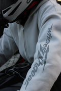 Close-up of the WHERES7THGEAR logo on a white hoodie sleeve