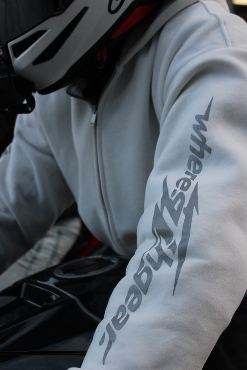 Close-up of the WHERES7THGEAR logo on a white hoodie sleeve