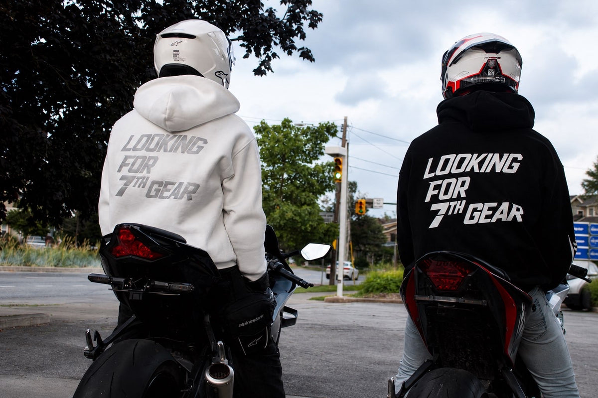 Two riders on motorcycles from behind wearing LOOKING FOR 7TH GEAR hoodies